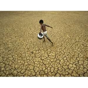 Indian Village Boy Runs Through a Parched Field on World Water Day in 
