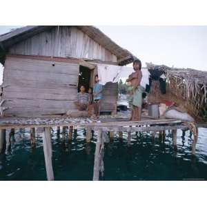 Bajau Family in Stilt House Over the Sea, with Fish Drying on Platform 